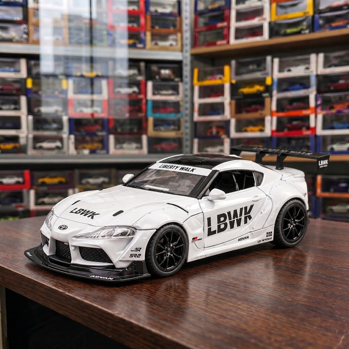 White Toyota Supra Liberty Walk 1:24 die-cast car displayed in a JDM model car collection