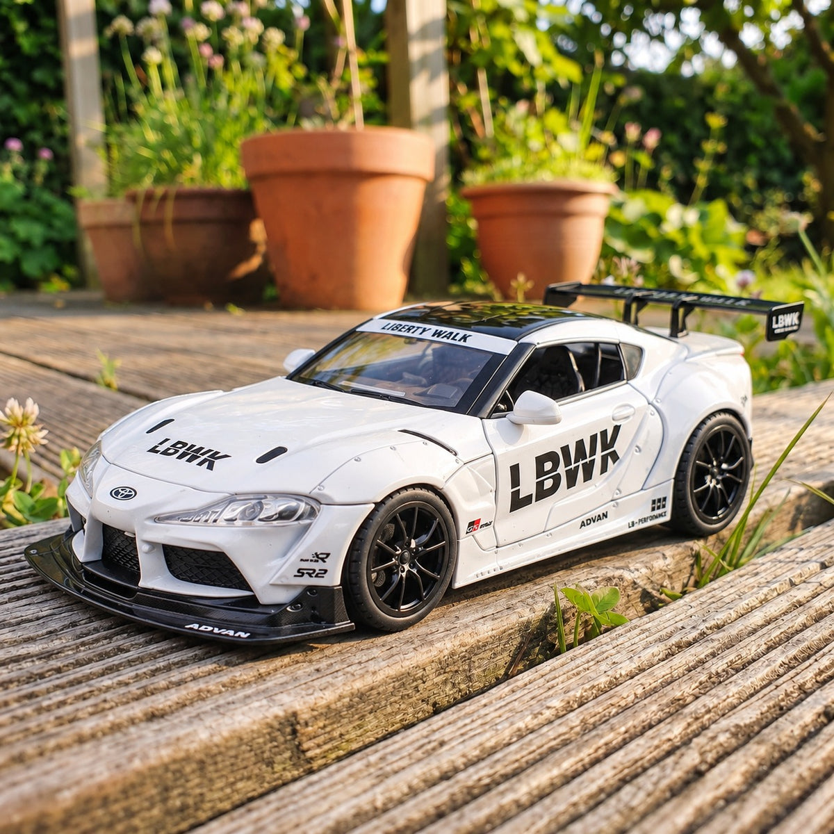 Toyota Supra MK5 Liberty Walk 1:24 die-cast model car photographed outdoors on a wooden deck